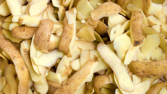 Viele Kartoffelschalen liegen auf einer Fläche.