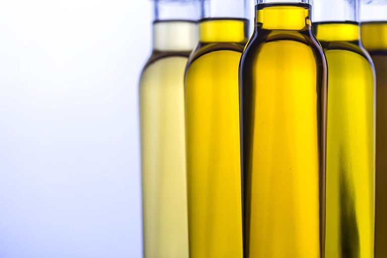 Mehrere Flaschen Olivenöl mit leicht unterschiedlichen Farbnuancen 