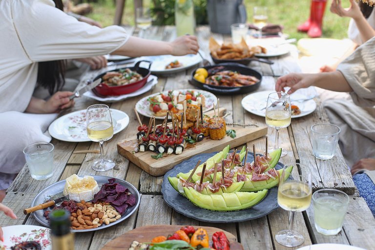 Gedeckter Gartentisch mit Menschen die essen